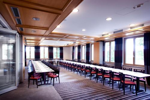 a row of tables and chairs in a room with windows at Hotel Restaurant Anna in Schnelldorf