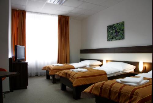 a hotel room with two beds and a television at Sport-Relax Centrum Bors Club in Břeclav