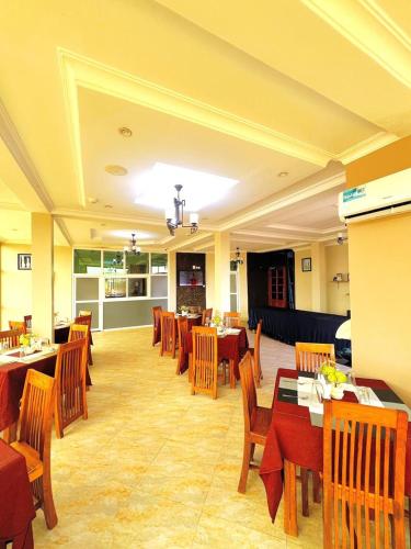 a restaurant with tables and chairs in a room at Rejis Hotel in Dodoma