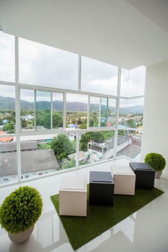 a room with two chairs and a large window at The Elysium Residence - SHA Extra Plus in Chalong 