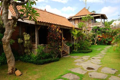 ein Haus mit einem Garten davor in der Unterkunft Nauna Villa Bali in Ubud