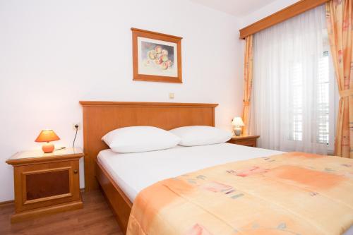 a bedroom with a large bed and a window at Apartments Residence Astoria in Rab