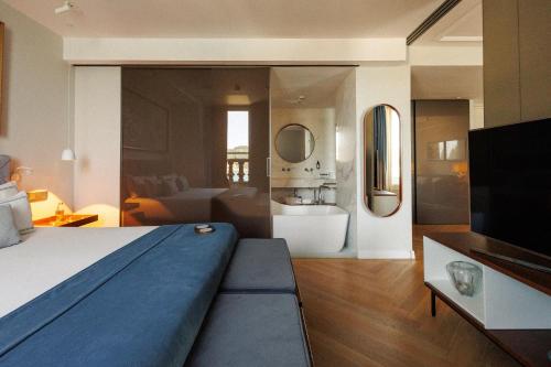 a bedroom with a bed and a living room at Lasala Plaza Hotel - Adults Only in Donostia-San Sebastián