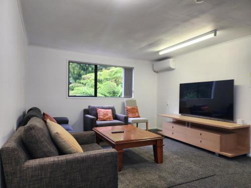 a living room with a couch and a flat screen tv at Entire home in Birkenhead in Auckland