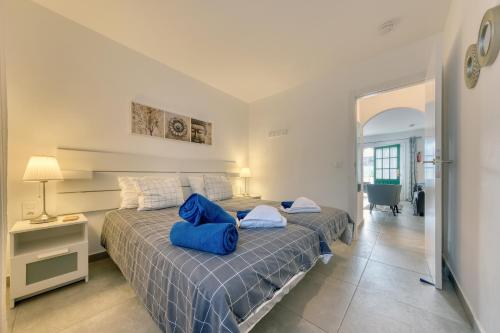 een slaapkamer met een bed met blauwe kussens erop bij Carpe Diem - Shared Pool By Lanzarote Vacation Homes in Puerto del Carmen