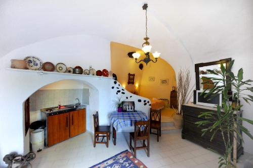 cocina y sala de estar con mesa y sillas en Kavalari Hotel - Adults Only en Fira