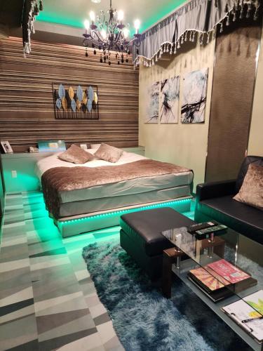 een slaapkamer met een bed, een bank en een tafel bij ホテルメイプル in Odate