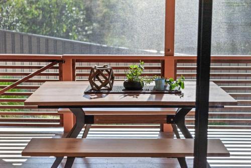 een houten tafel met planten op een balkon bij Narrawallee Oasis in Narrawallee