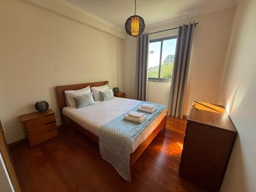 a small bedroom with a bed and a window at Madeira Sun Loft in Funchal in Funchal