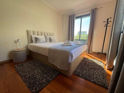 a bedroom with a large bed with a large window at Madeira Sun Loft in Funchal in Funchal