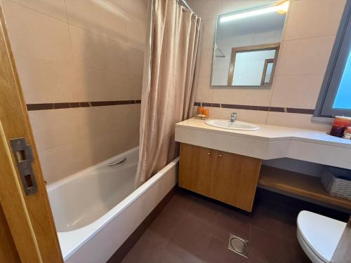 a bathroom with a sink and a tub and a toilet at Madeira Sun Loft in Funchal in Funchal