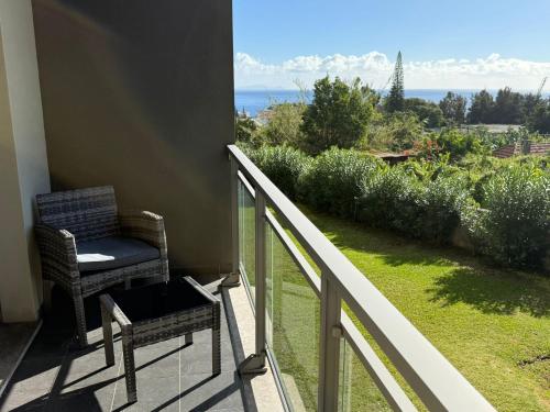 a balcony with a chair and a view of the ocean at Madeira Sun Loft in Funchal in Funchal