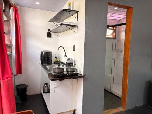 een keuken met een aanrecht met potten en pannen erop bij Chalé Black no Sul da Ilha in Florianópolis