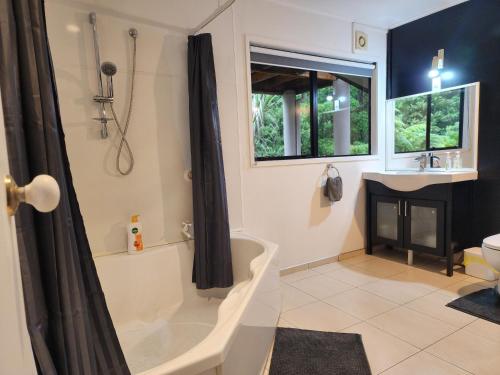 a bathroom with a tub and a sink at Entire home in Birkenhead in Auckland