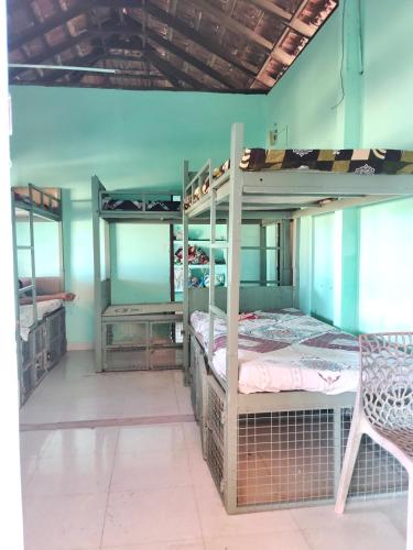 a room with two bunk beds and a chair at Lakecampers for foreign travellers in Alleppey