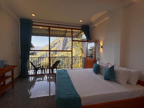 a bedroom with a bed and a balcony with a view at Green Mount Eye Ella in Ella