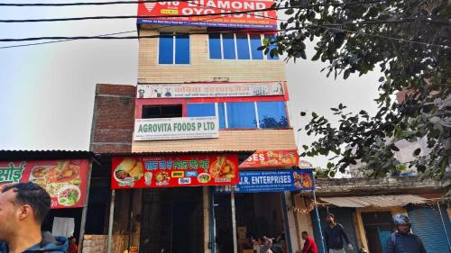 a tall building with signs on the side of it at SPOT ON Diamond Hotel in Rāmpura