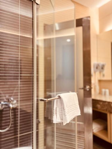 a bathroom with a glass shower with a towel at Yunlin hotel in Tuku