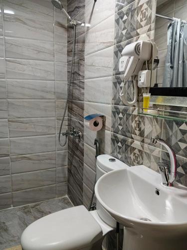 a bathroom with a toilet and a sink at Kahraman Amman Hotel in Amman