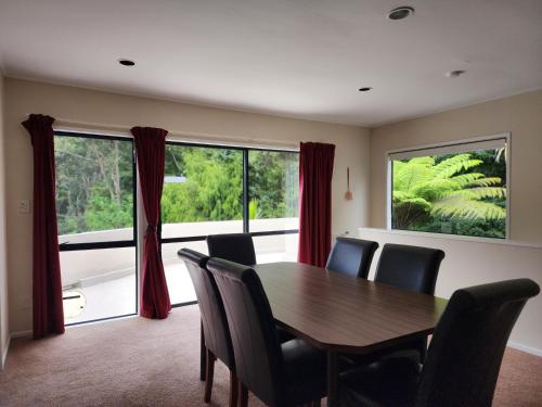 a dining room with a table and chairs and a large window at Entire home in Birkenhead in Auckland