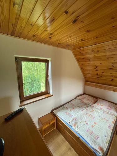 een kleine slaapkamer met een bed en een raam bij Agroturystyka u Dudków- Balia i Apiterapia in Jeleśnia