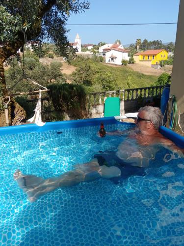 an older man laying in a swimming pool at Casa da Casimira in Miranda do Corvo