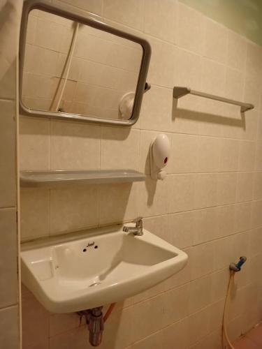 a bathroom with a sink and a mirror on the wall at D Love Gueshouse in Ranong