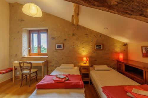 une chambre avec deux lits, une table et un bureau dans l'établissement Gite de Marbois, 