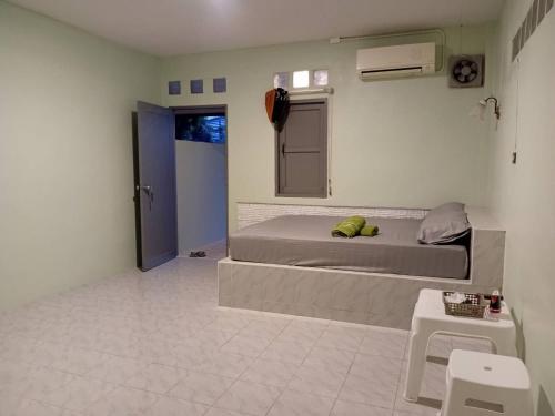 una piccola camera da letto con un letto e un tavolo di D Love Gueshouse a Ranong