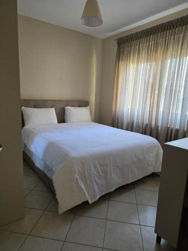 亚历山德鲁波利斯Garden Bliss 1 Alexandroupolis的卧室里有一张白色的大床和一扇窗户