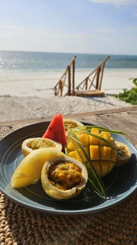 ein Teller mit Obst am Strand in der Unterkunft Natural Park Villa Resort in Pingwe