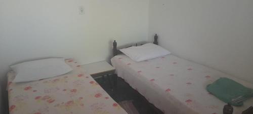 twee bedden naast elkaar in een kamer bij Cantinho da Dê in Anchieta