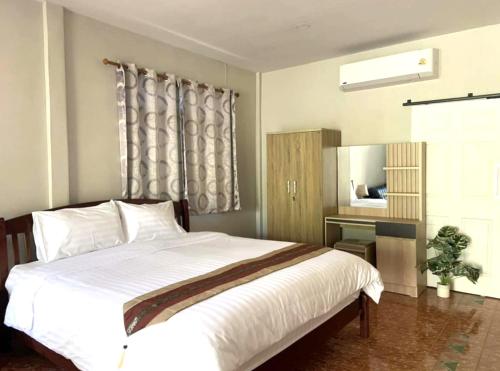 ein Schlafzimmer mit einem großen weißen Bett und einem Schreibtisch in der Unterkunft Khaolak Beachhouse Kelolo in Khao Lak