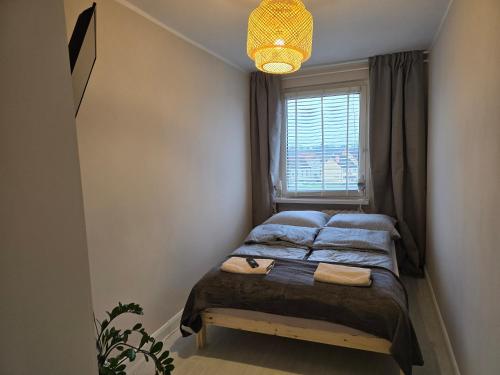 een kleine slaapkamer met een bed en een raam bij Apartment Cherry in Gryfice