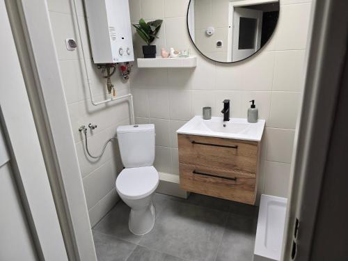een badkamer met een toilet, een wastafel en een spiegel bij Apartment Cherry in Gryfice
