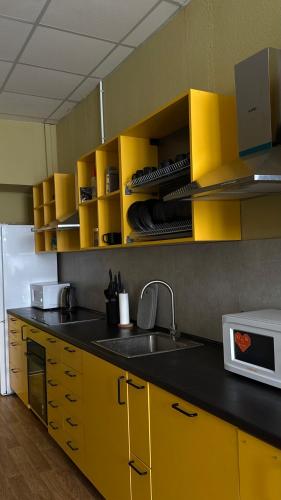 a kitchen with yellow cabinets and a sink at Трініті Хаус in Kyiv