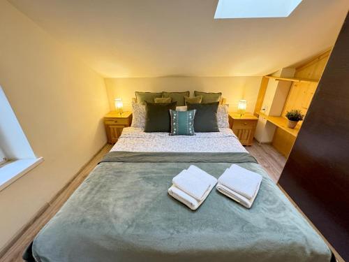 een slaapkamer met een groot bed met twee handdoeken erop bij Przystanek Rabka - Domek całoroczny in Rabka