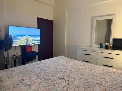 een slaapkamer met een bed en een flatscreen-tv bij Shared Apartment Room with Private Washroom in Sharjah