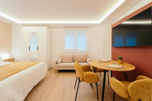 een slaapkamer met een bed, een tafel en stoelen bij Fuente H1 in Jaén