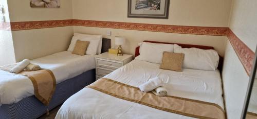 een slaapkamer met 2 bedden en een nachtkastje ertussen bij Lily Hotel Blackpool in Blackpool