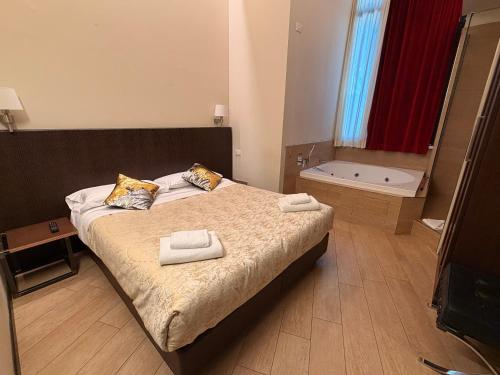 una camera da letto con un letto con due asciugamani sopra di Arena Luxury Suite a Verona