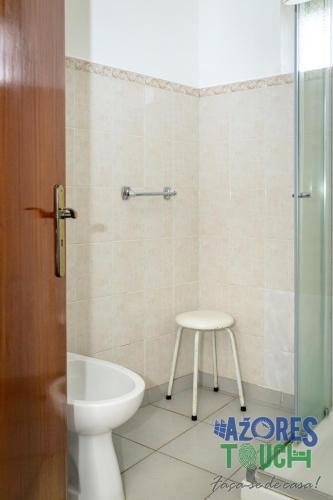 a bathroom with a toilet and a stool in it at Hospedaria casa D'Avo in Praia da Vitória