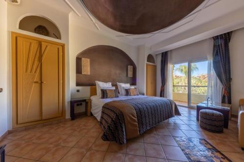 ein Schlafzimmer mit einem Bett und einem großen Fenster in der Unterkunft Villa Riadana in Agadir