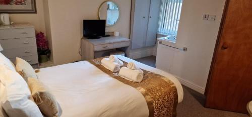 een slaapkamer met een groot bed met twee handdoeken bij Lily Hotel Blackpool in Blackpool