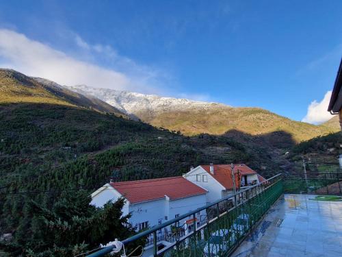 een wit gebouw met een rood dak op een berg bij Piscinas, Serra da Estrela AL in Bouça