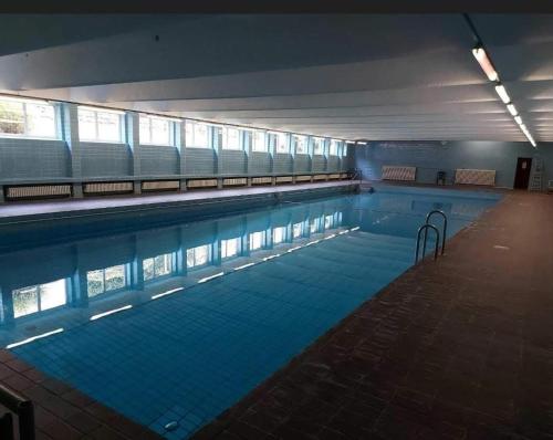 een groot zwembad met blauw water in een gebouw bij Wohnung wie Zuhause in Bergheim