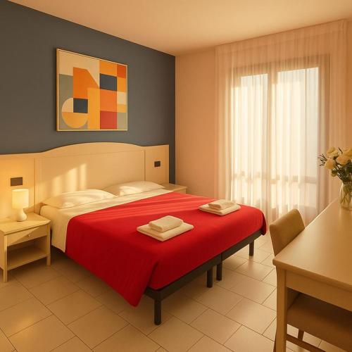 a bedroom with a red bed with a red blanket at The Park Hotel in Fanano