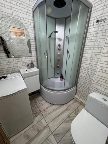 een badkamer met een douche, een toilet en een wastafel bij Panorama Spa Apartment in Berehove