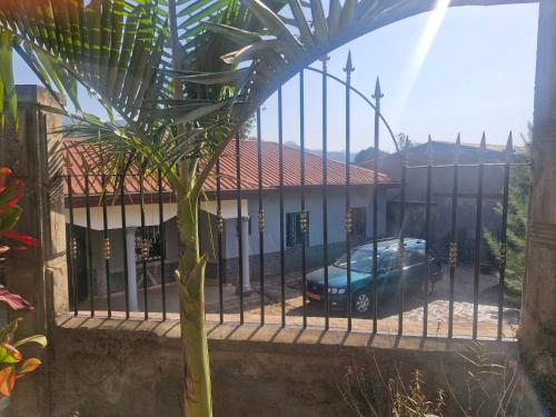 een auto geparkeerd voor een gebouw achter een hek bij Villa Valentine in Bana
