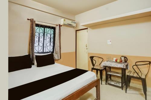 ein Schlafzimmer mit einem Bett und einem Tisch und einem Fenster in der Unterkunft Hotel O Arambol Beach Formerly Hakuna Matata in Arambol